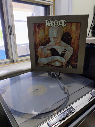 Record player and album cover for Warning - The Albums